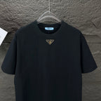 Prada black short-sleeve T-shirt with small gold triangle logo, front view