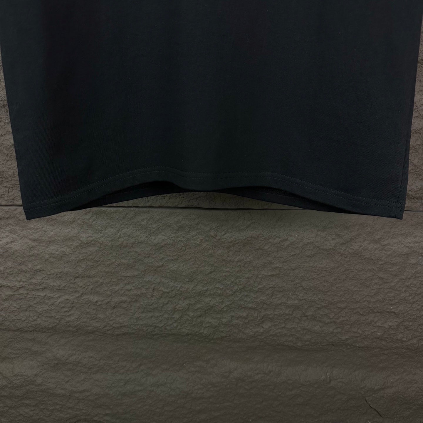 Prada black short-sleeve T-shirt hem and lower front, cropped view