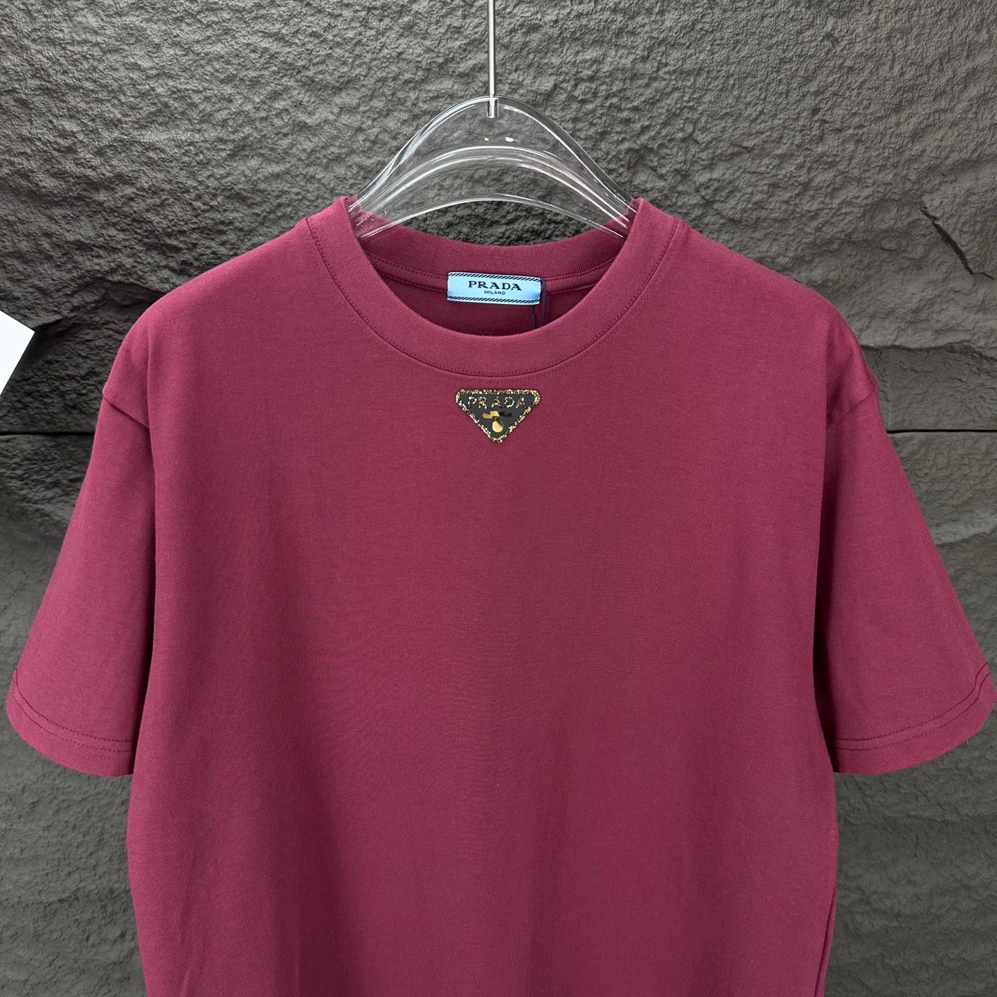 Maroon short-sleeve T-shirt with triangular logo at the chest