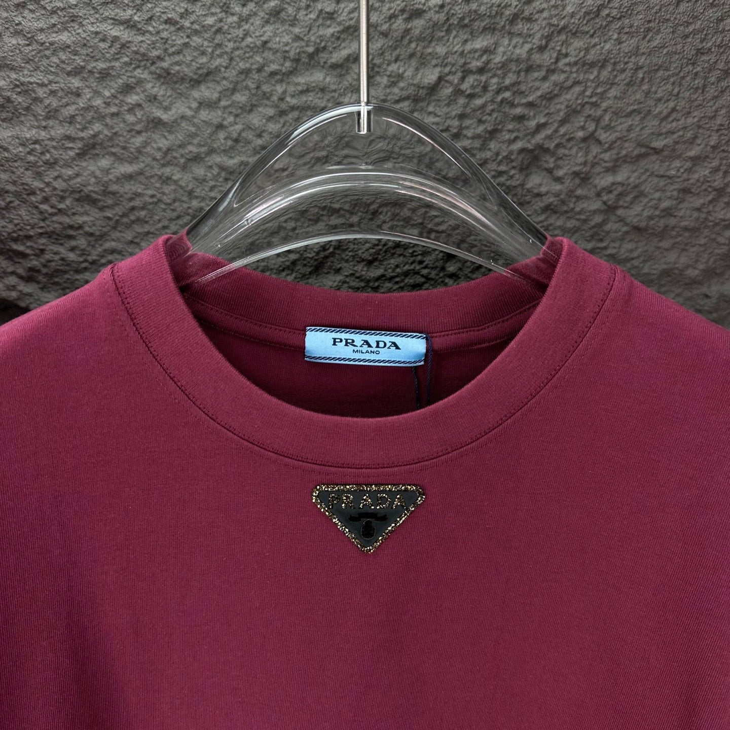 Maroon short-sleeve T-shirt with triangular logo near the neckline