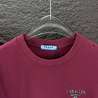 Prada short-sleeve T-shirt neckline with PRADA logo on dark berry fabric.