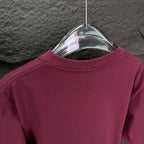 Prada short-sleeve T-shirt back neckline in dark berry on a transparent hanger.