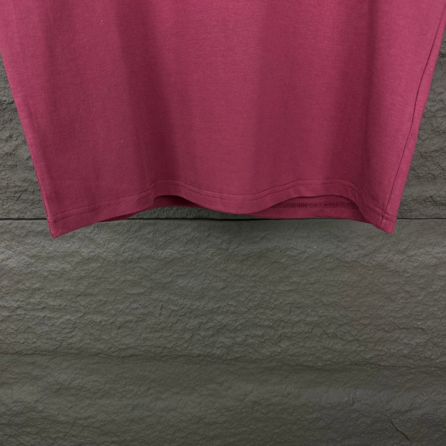 Prada short-sleeve T-shirt hem in dark berry, underside view.