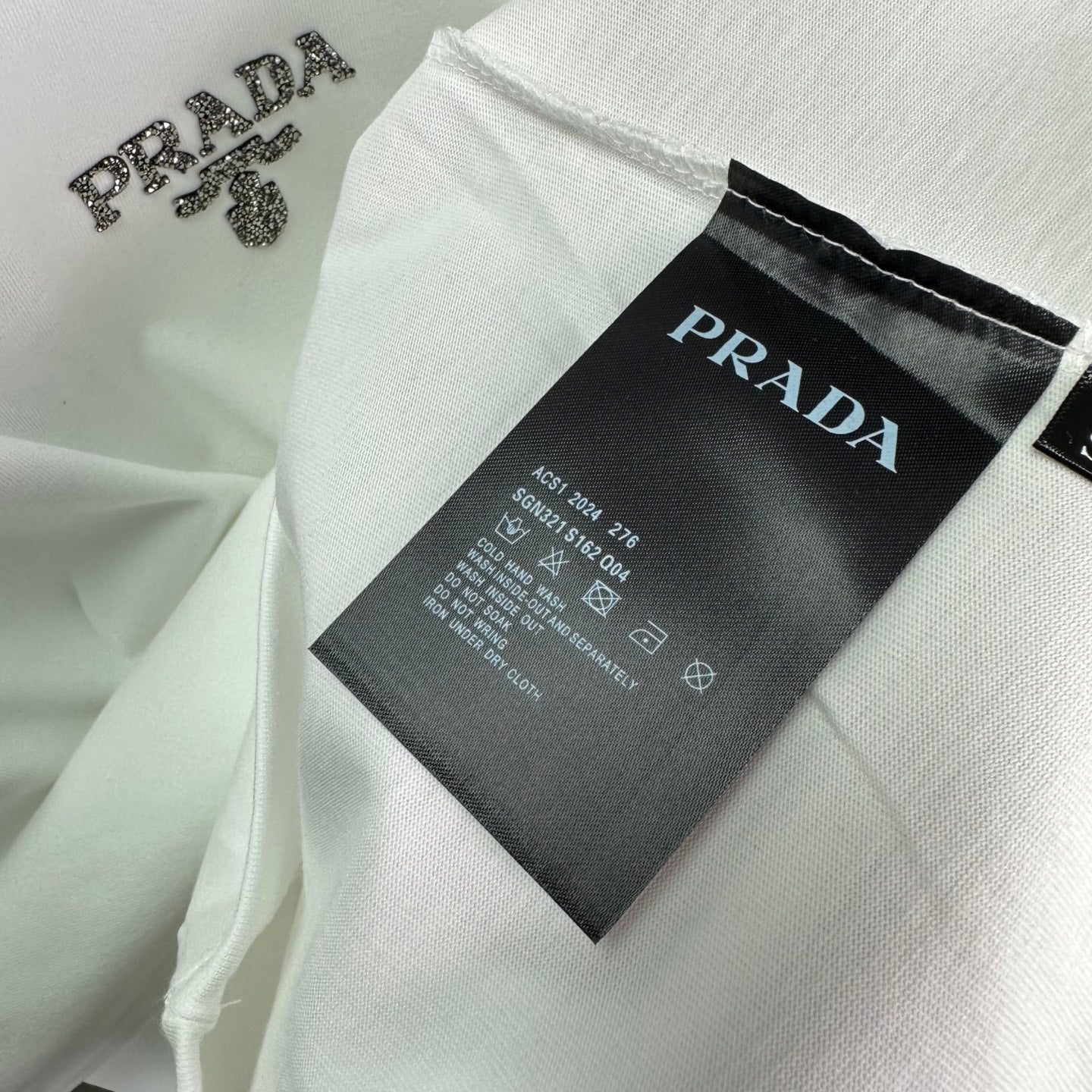 PRADA clothing label tag on white T-shirt