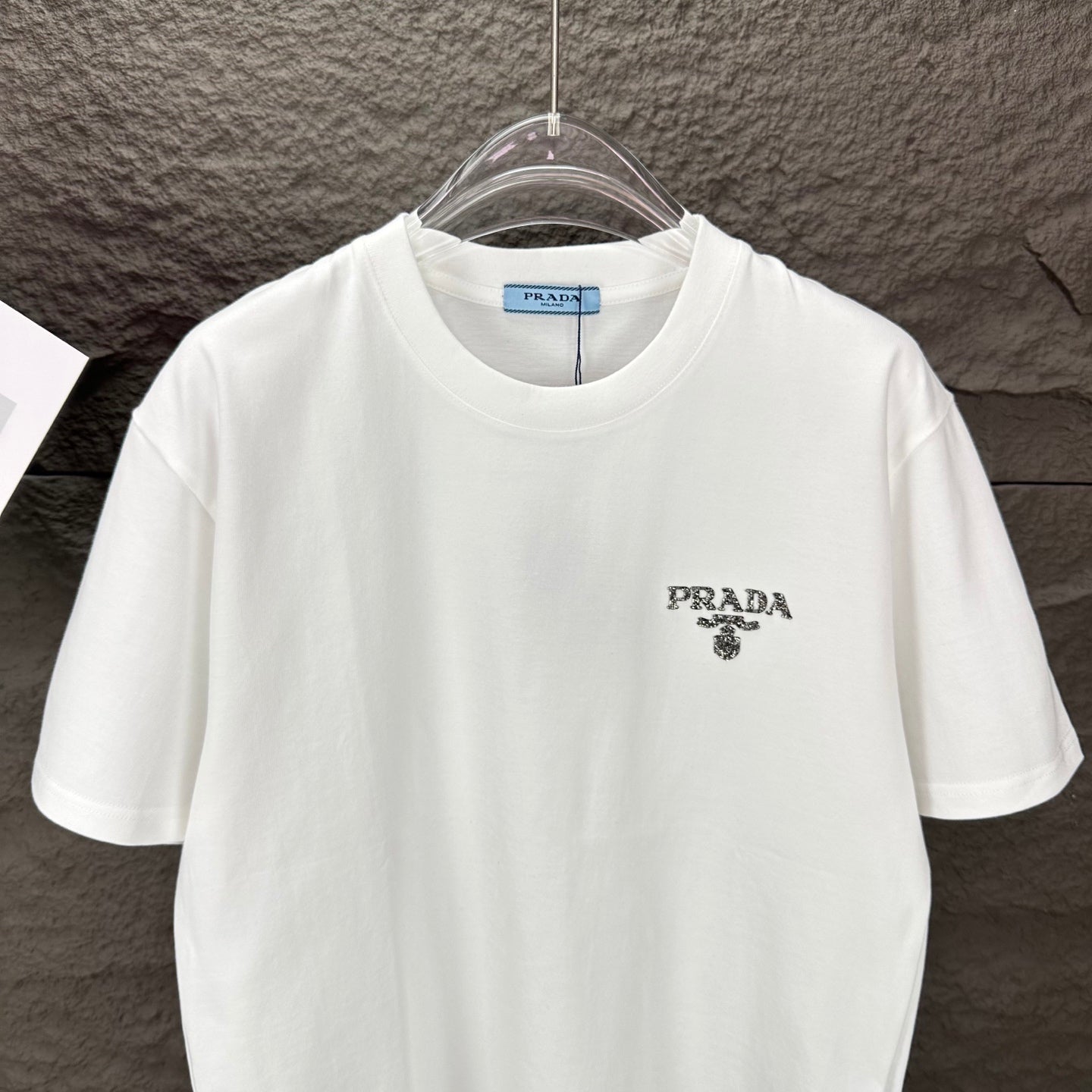 White short-sleeve T-shirt with PRADA logo on left chest, front view