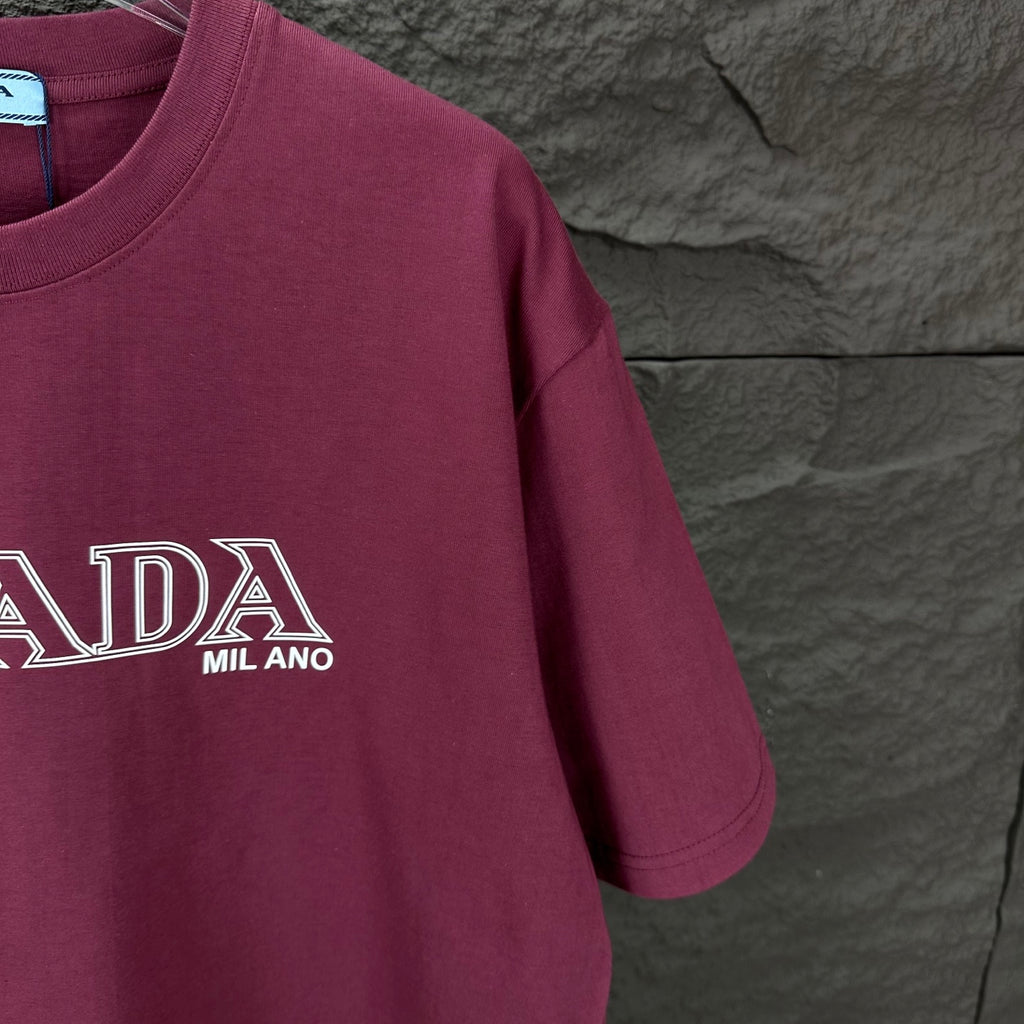 Burgundy crewneck Prada T-shirt sleeve detail with PRADA MIL ANO logo
