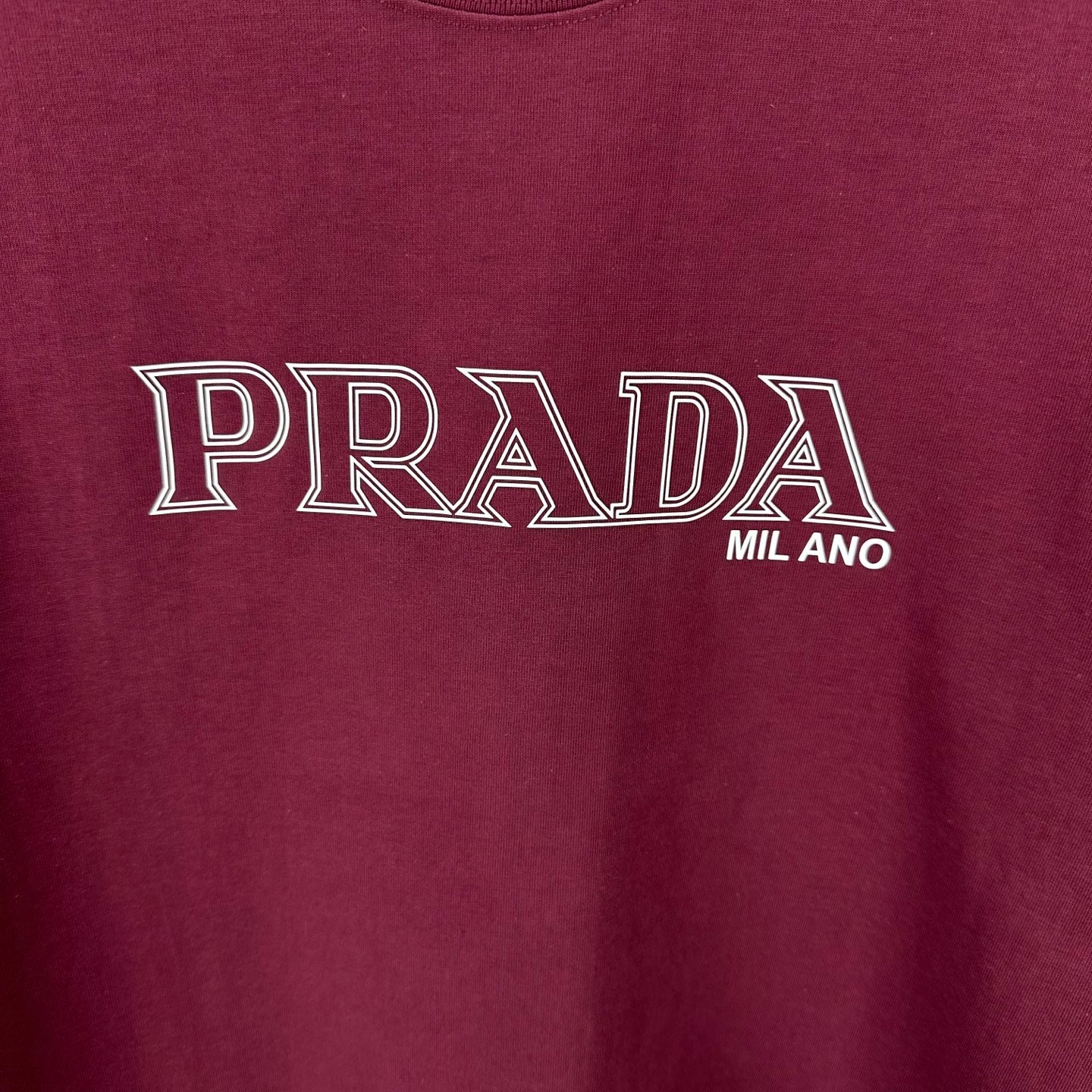 Burgundy T-shirt with PRADA MIL ANO logo print at center