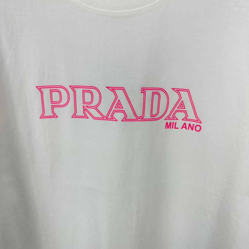 White T-shirt with large pink PRADA MIL ANO logo graphic on the front.