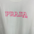 White T-shirt with large pink PRADA MIL ANO logo graphic on the front.