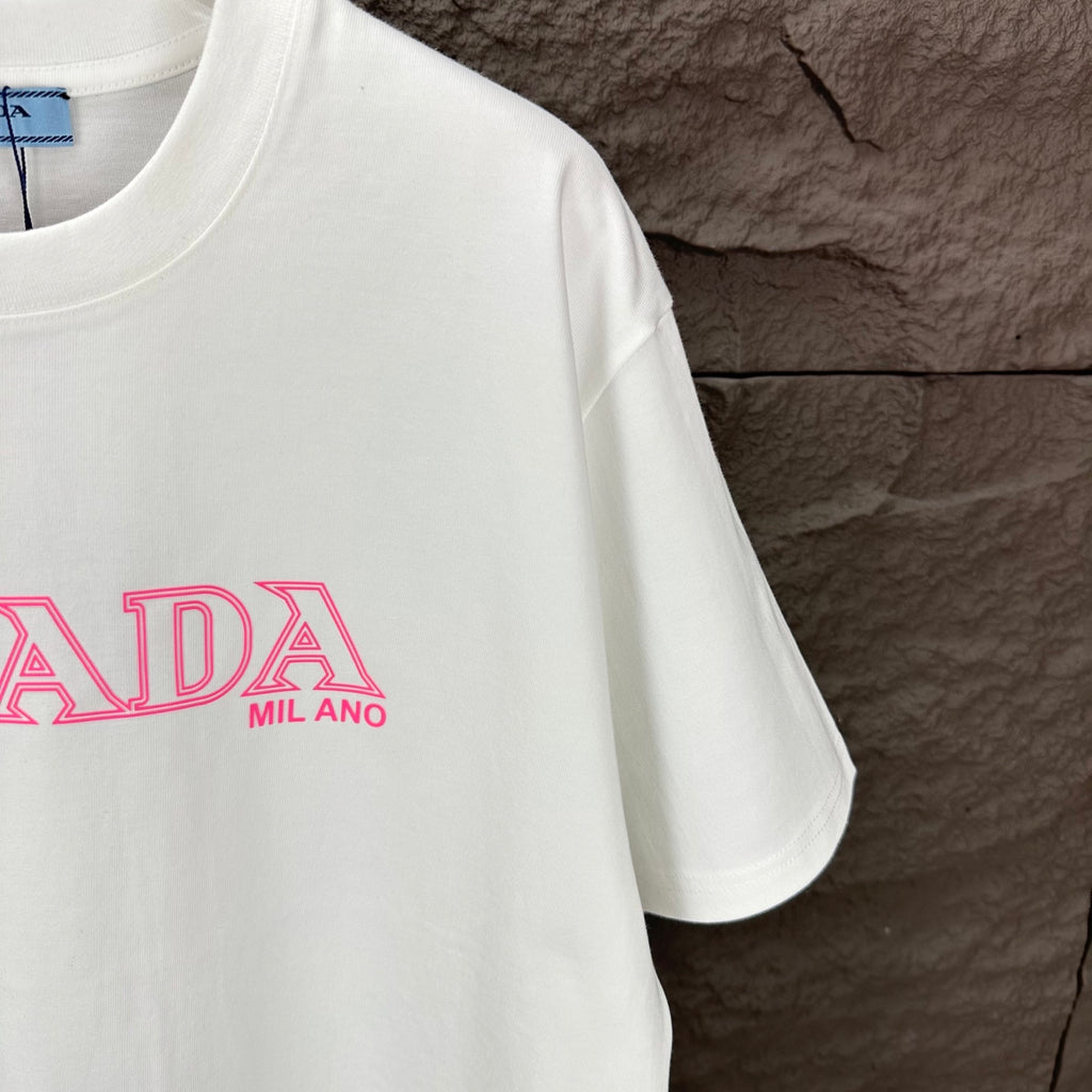 White short-sleeve T-shirt with partial pink PRADA MIL ANO logo print.