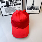 Red baseball cap with side bow, curved brim and stitched panels.