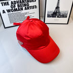 Red baseball cap angled view with fabric bow and curved brim.