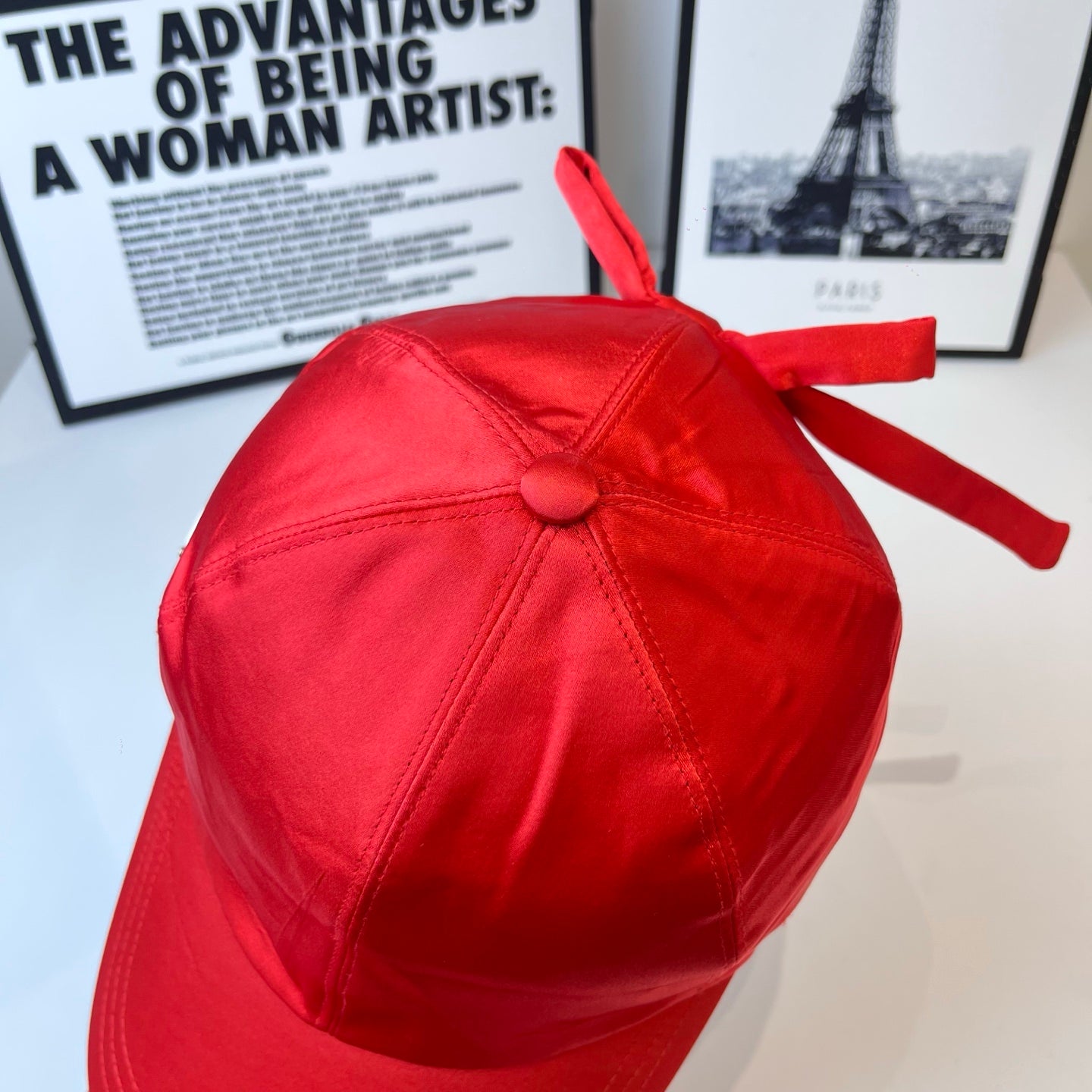 Red baseball cap with top knot detail and curved brim.