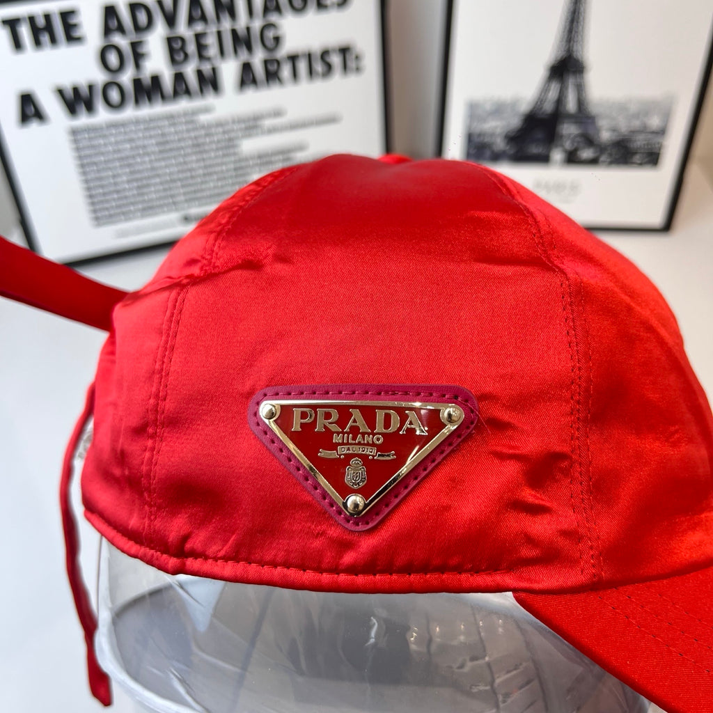 Red cap with triangular Prada logo patch on front panel.