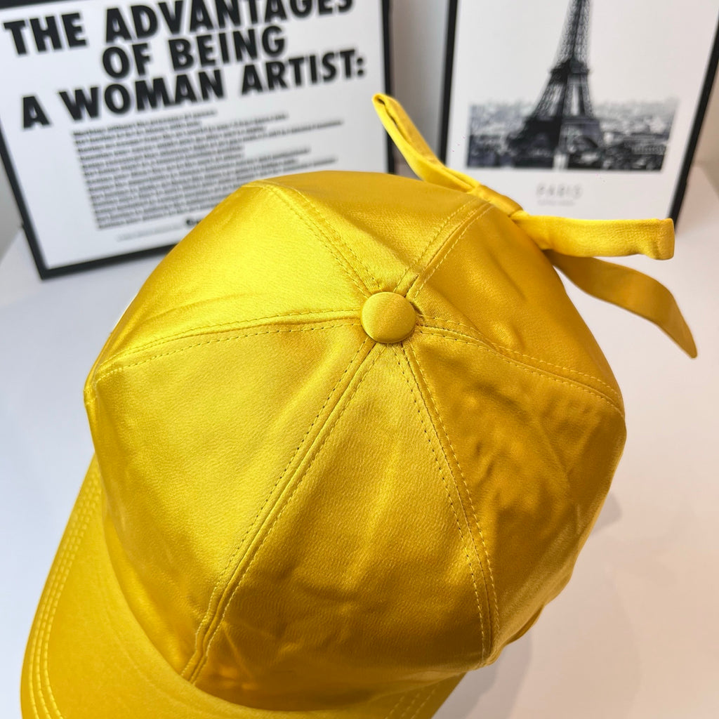 Prada yellow satin cap with center button on the back panel and ribbon ties