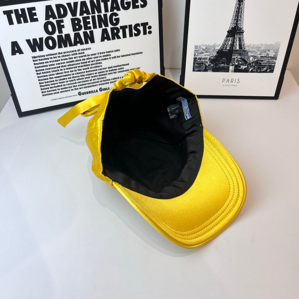 Prada yellow satin cap open to show black lining and small interior tag