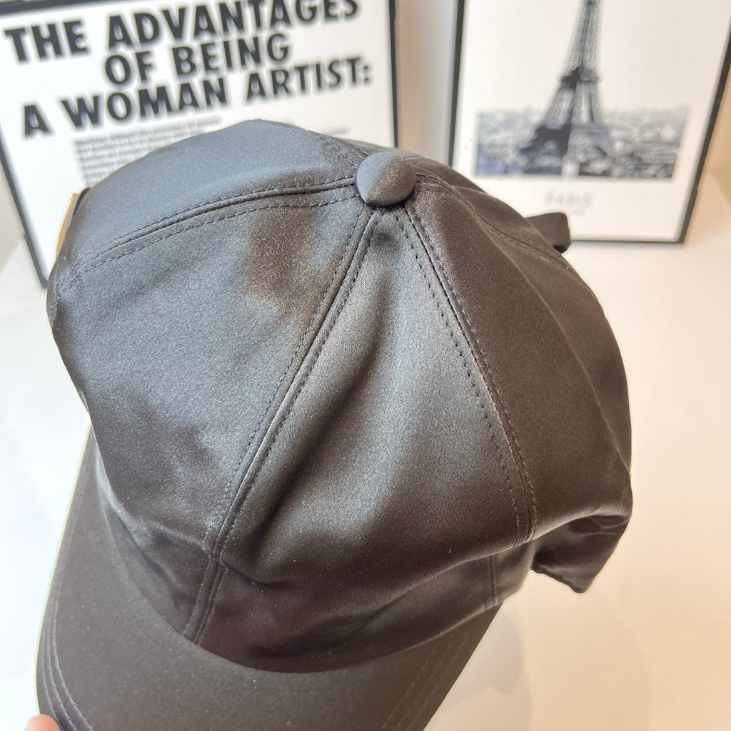 Prada cap side view with top button and curved panel stitching in gray.