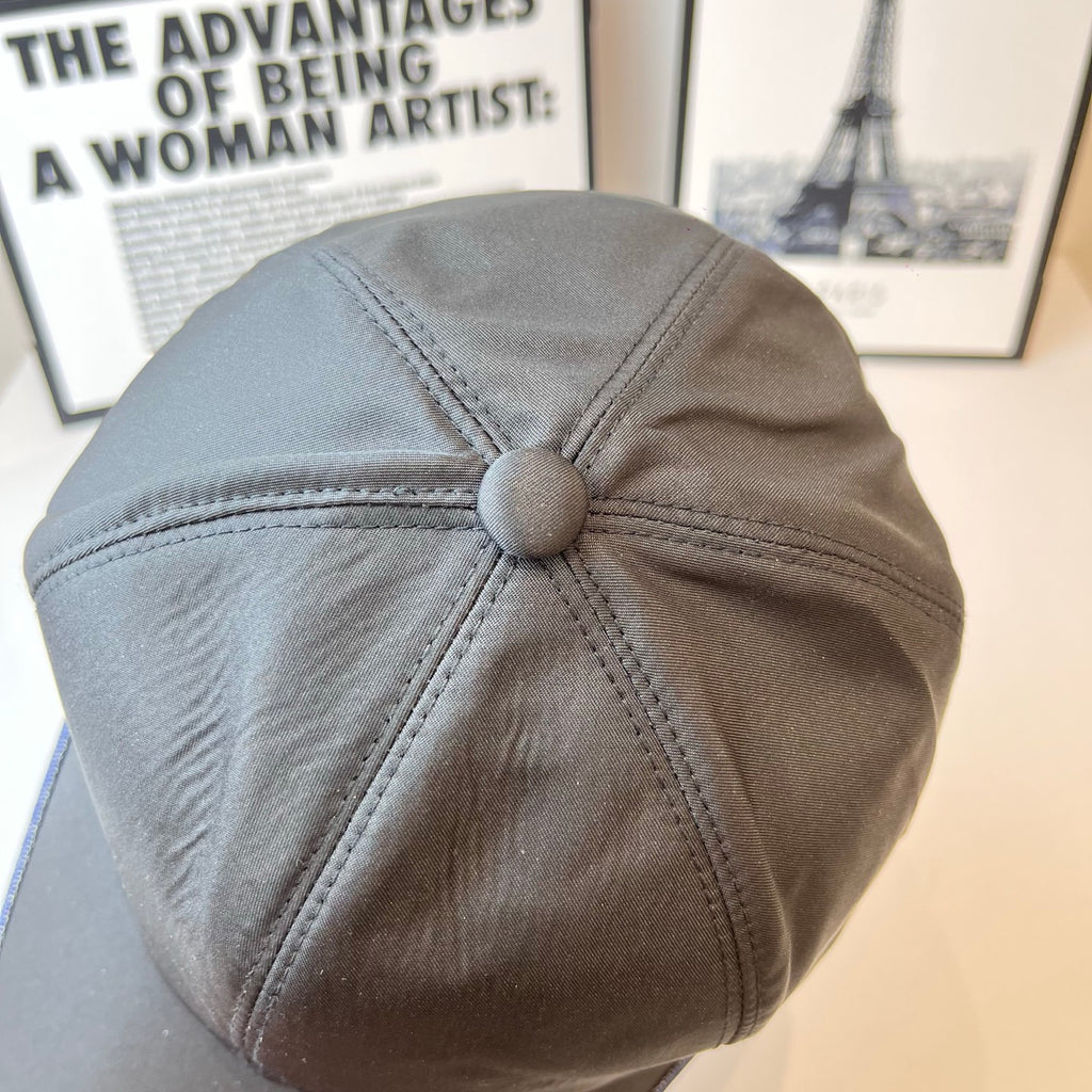 Navy Prada cap with buttoned crown top, stitched panels, and blue contrast brim trim.