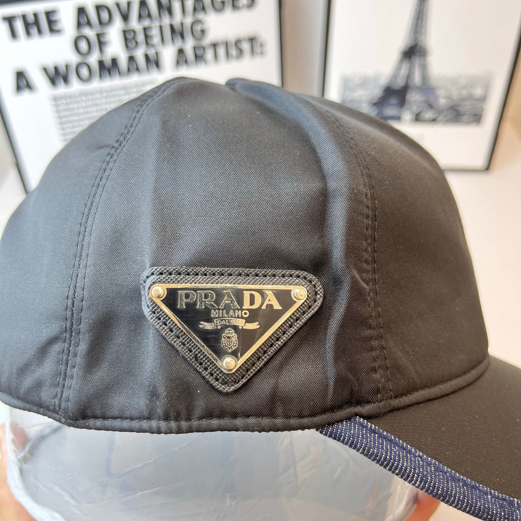 Navy Prada cap with embroidered triangular PRADA label and blue contrast brim edge.