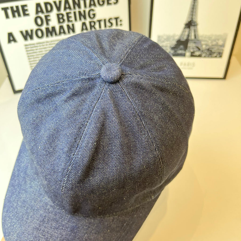 Prada denim cap in dark blue, back view with stitched seams and top button.