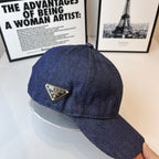 Prada denim cap in dark blue with gold logo patch on side.
