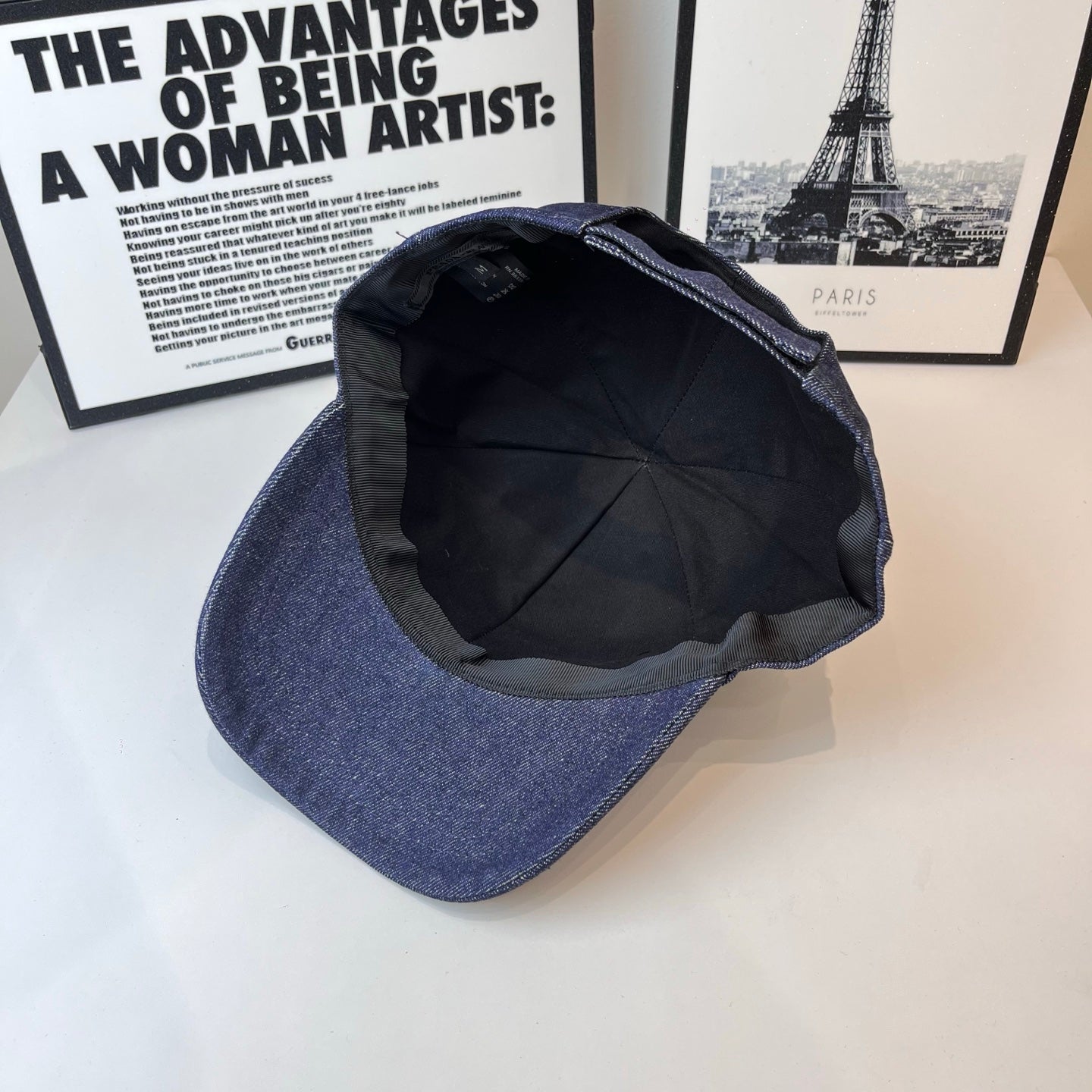 Prada denim cap interior view, black lining and curved brim opening.