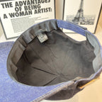Prada denim cap interior with black lining and small fabric tag near crown.
