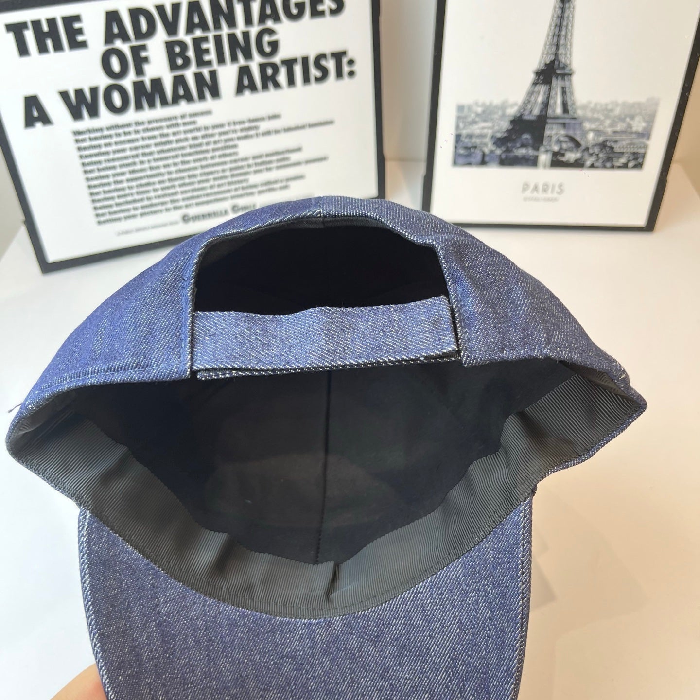 Prada denim cap interior view, black lining with front panel stitching.