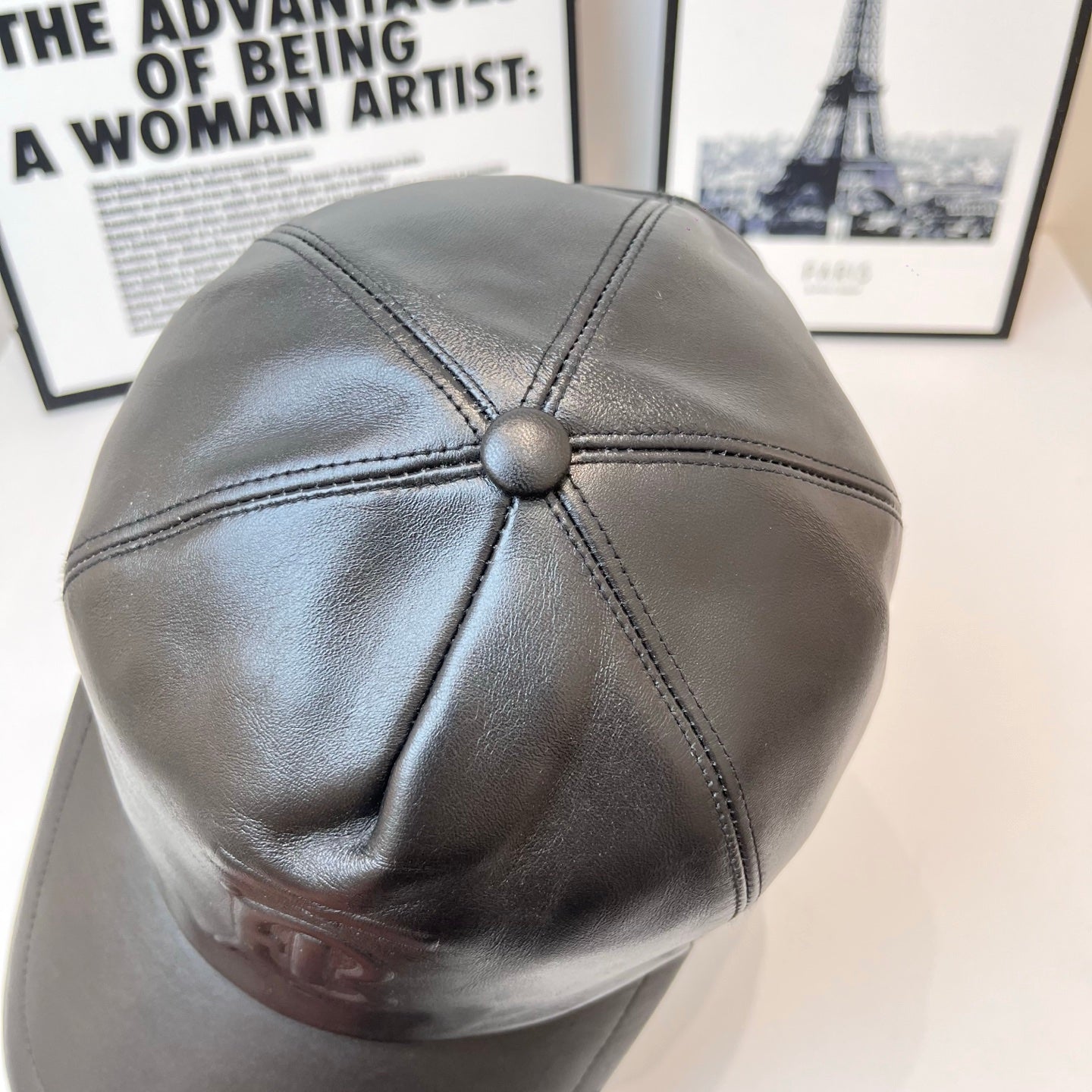Dark leather baseball cap with back button detail and stitched crown paneling