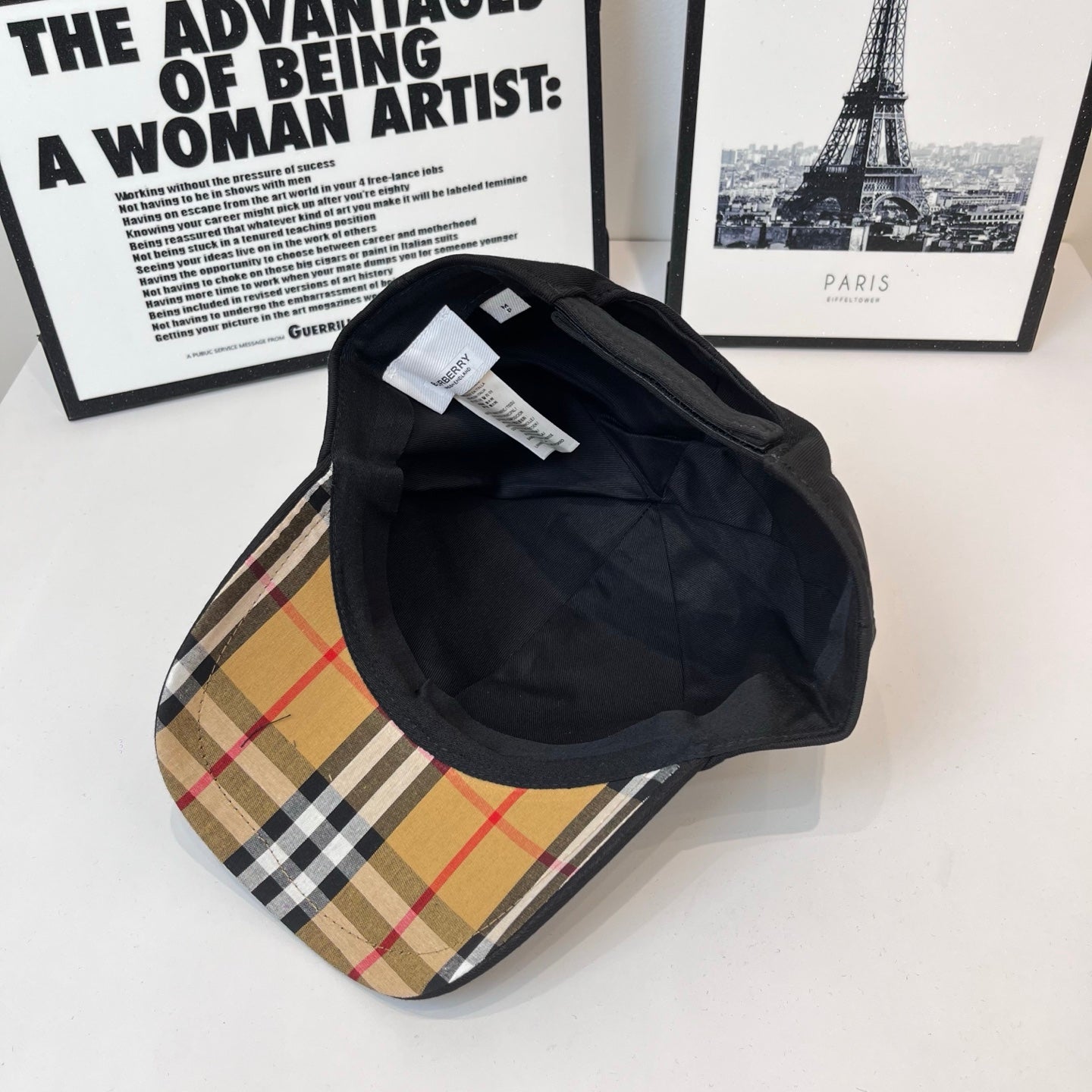 Black Burberry cap interior and underside view with inner label and quilted lining.