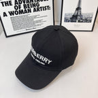 Black Burberry cap with side embroidered logo and "LONDON ENGLAND" text.