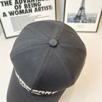 Black Burberry cap showing top panel seam and domed button; side logo partially visible.