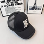 Black baseball cap with side mesh panels and white embroidered monogram logo