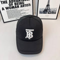 Black baseball cap with white embroidered monogram logo on front and curved brim