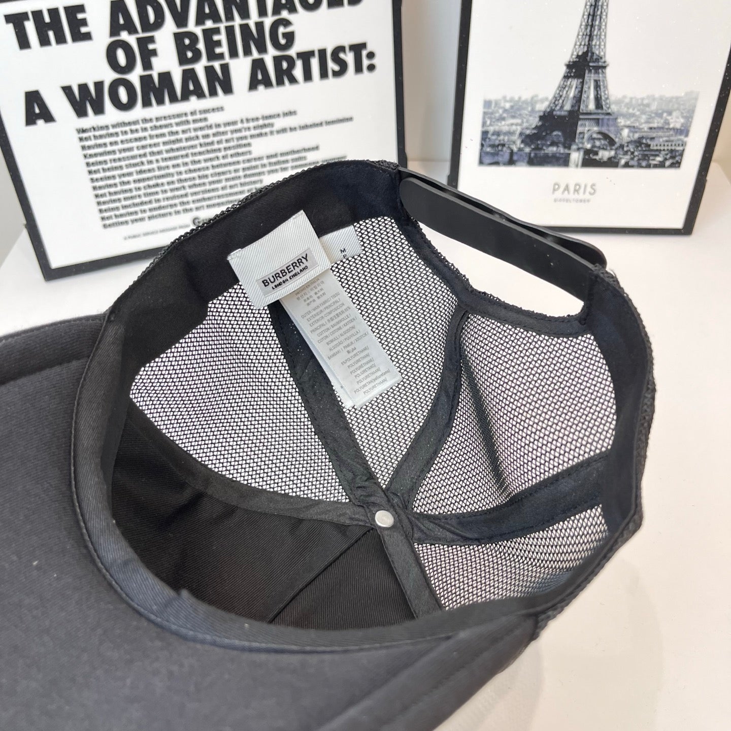 Black mesh-back cap interior with brand tag and buttoned opening near crown
