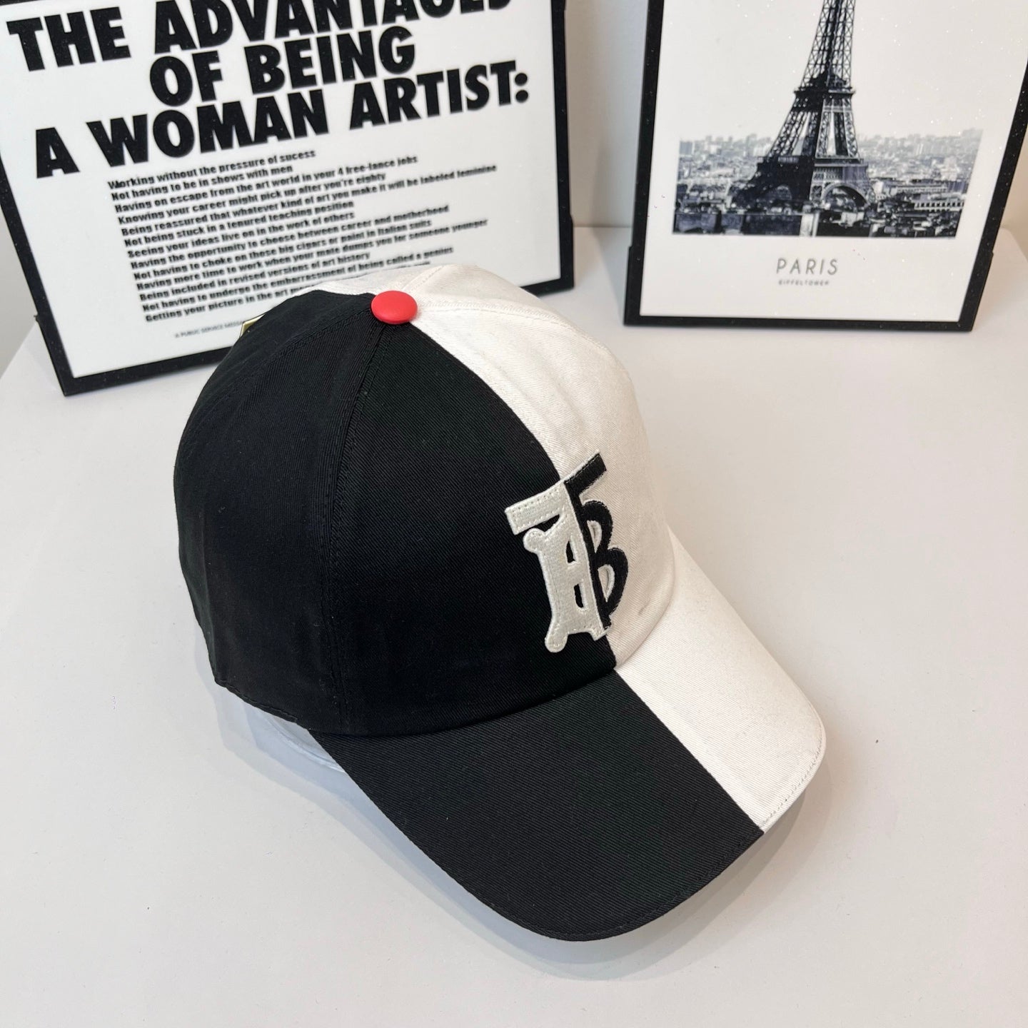 Two-tone Burberry cap with black crown and white panel, TB logo patch, red button