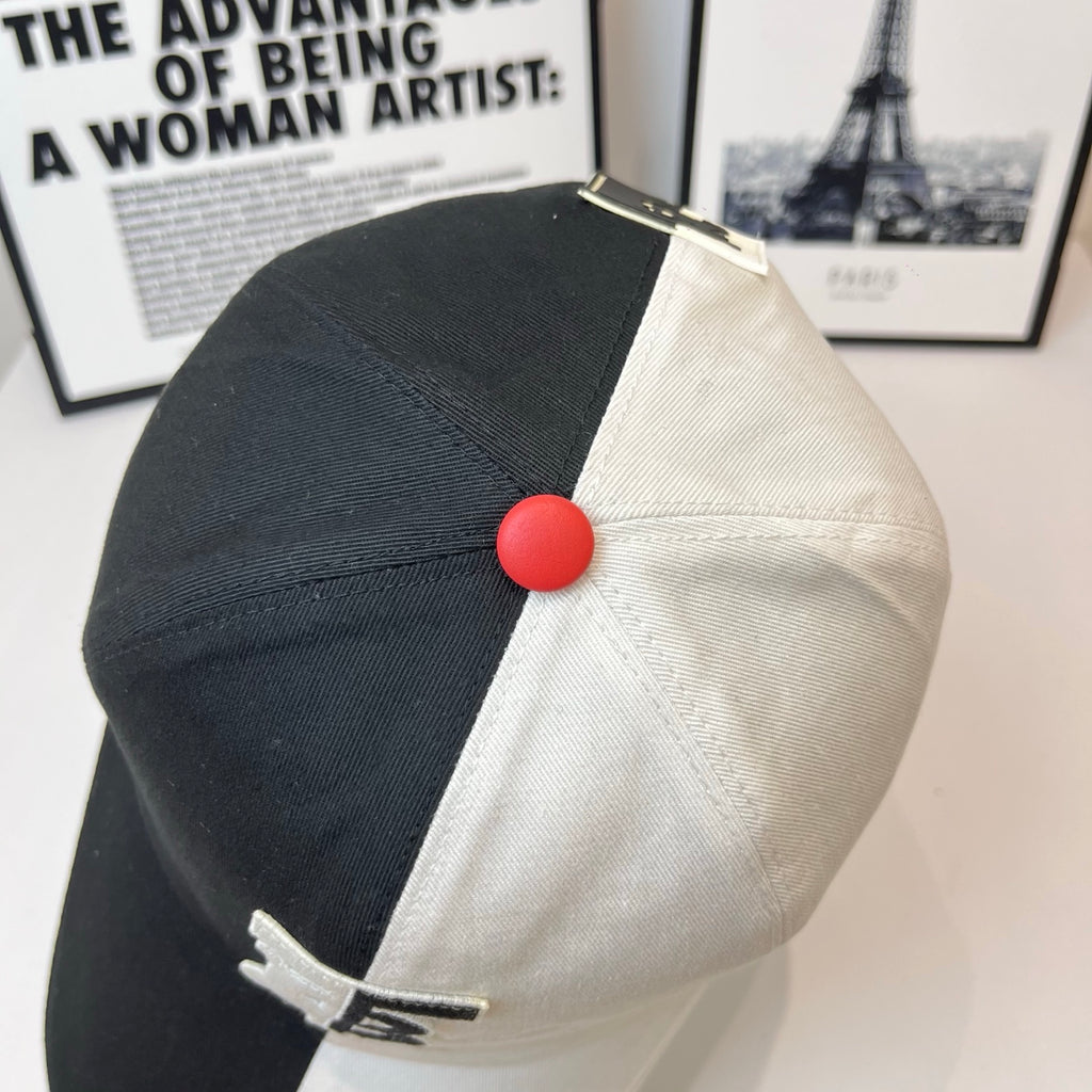 Two-tone Burberry cap with red top button and black-and-white crown panels