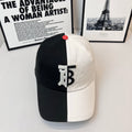 Two-tone Burberry cap with black crown, white brim, TB logo patch, and red button