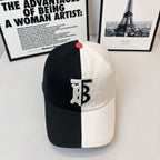 Two-tone Burberry cap with black crown, white brim, TB logo patch, and red button