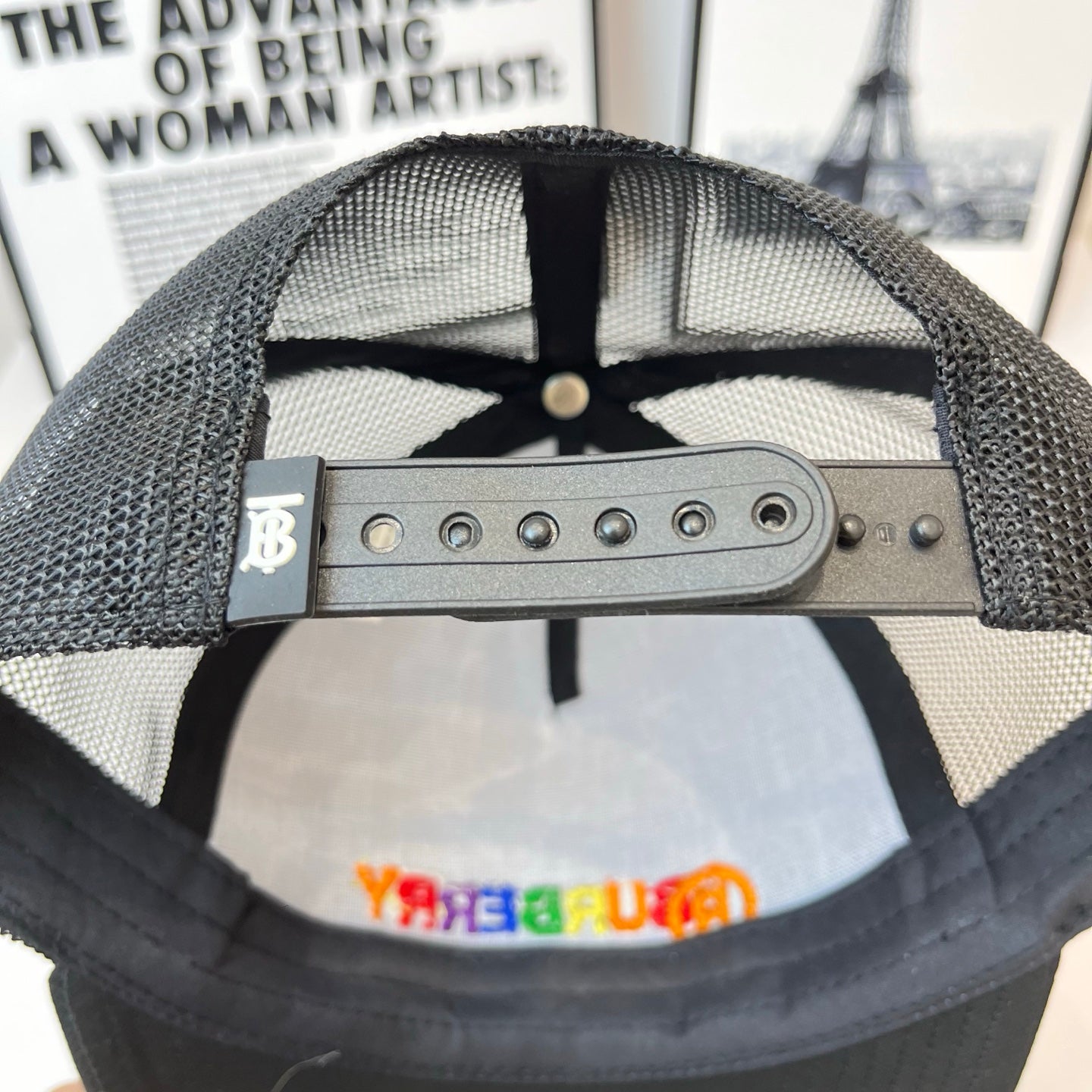 Black mesh cap interior with metal snap strap and eyelets