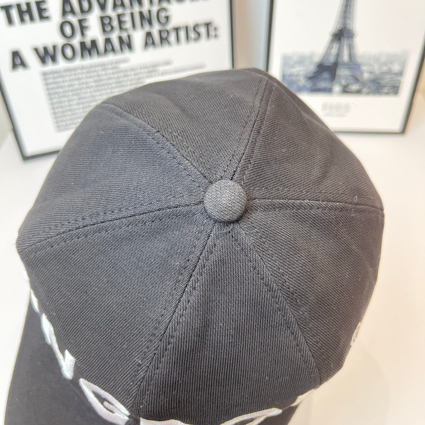 Gray fabric cap with round top button and stitched panel seams