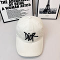 White canvas cap with black Dior logo embroidery.