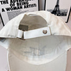 White canvas cap strap with metal buckle on back opening.