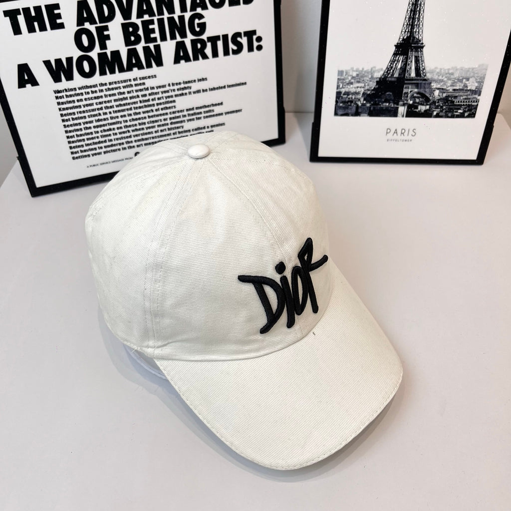 White canvas cap with black Dior logo, curved brim.