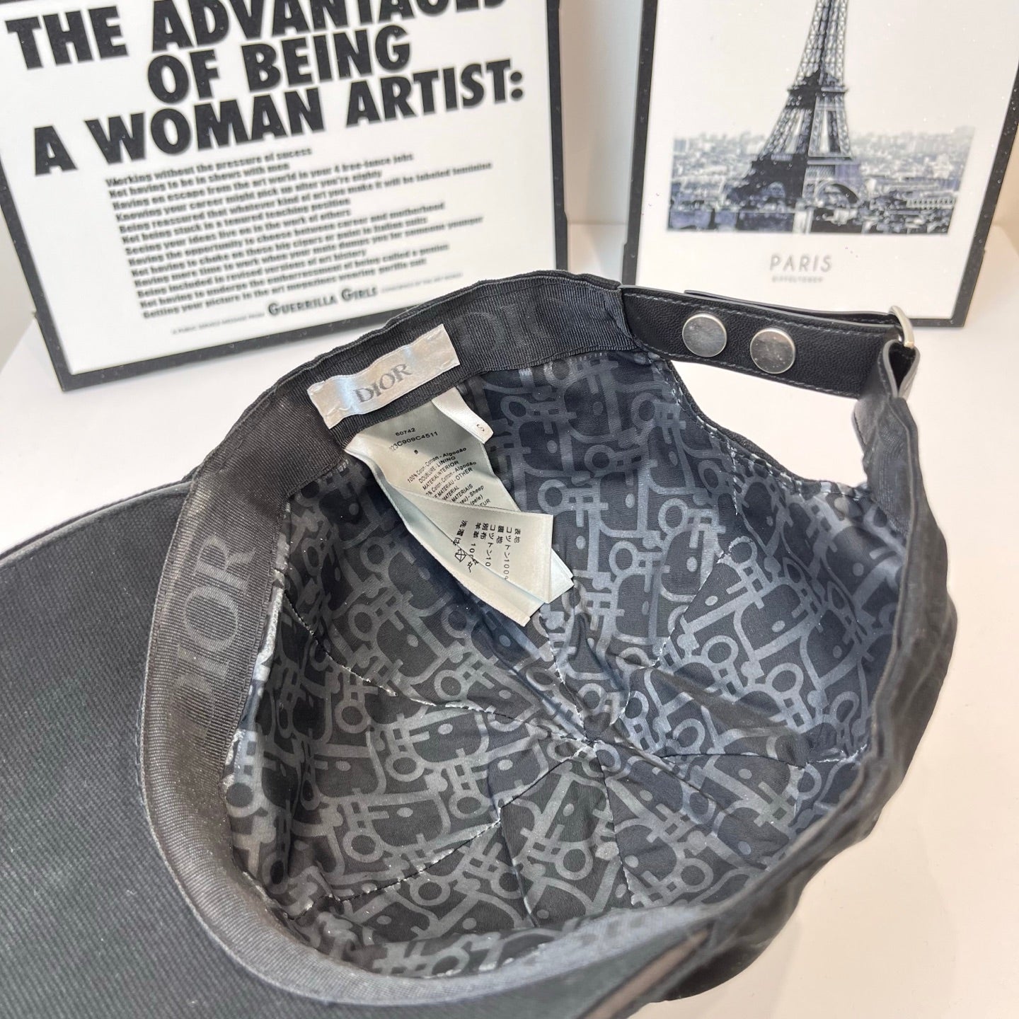 Cap interior with patterned lining, metal snap, and adjustable strap