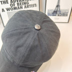 Gray baseball cap with round top button and curved brim