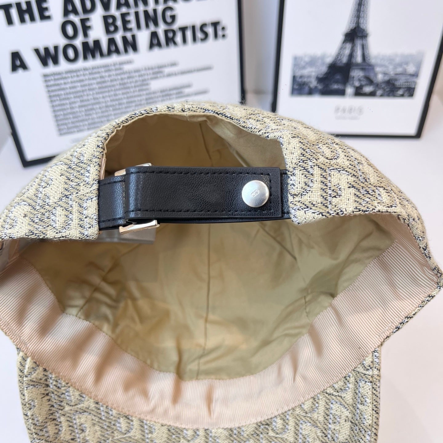 Dior cap interior with black adjustable strap and metal snap at back.