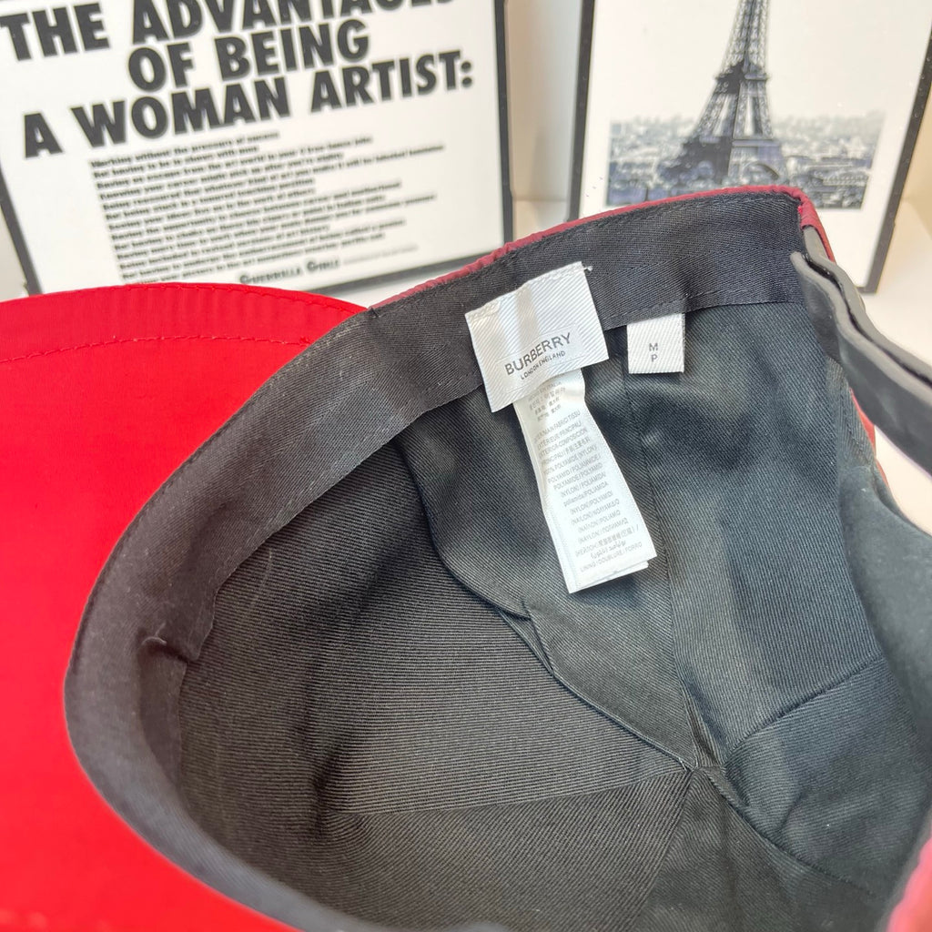 Red cap interior with black lining, Burberry label, and white tag