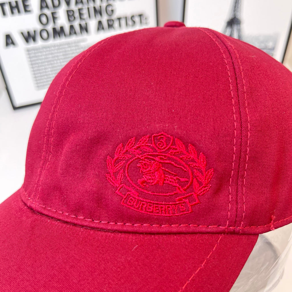 Burberry red cap close-up of embroidered crest on the front