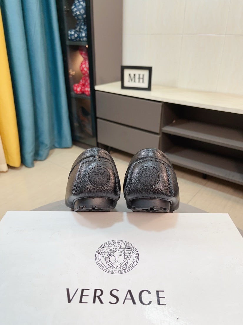 Black leather loafer back view with ridged heel and embossed logo